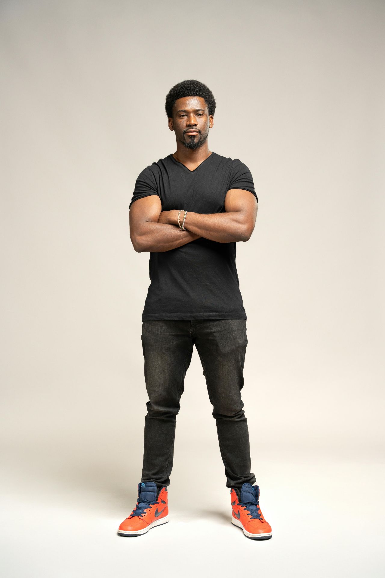 Kamanga standing in a black t-shirt and sneakers