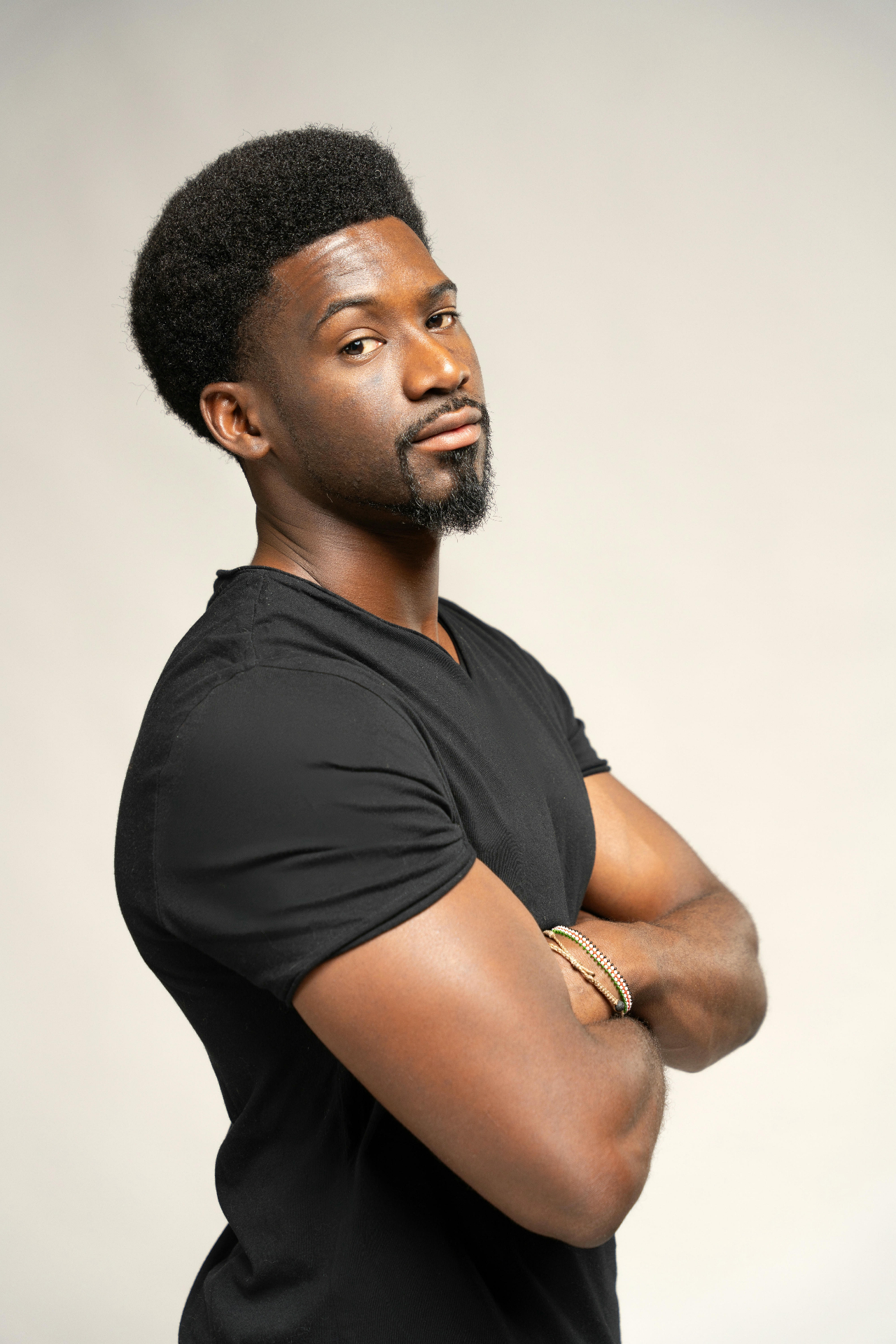 Kamanga arms crossed side portrait in black t-shirt