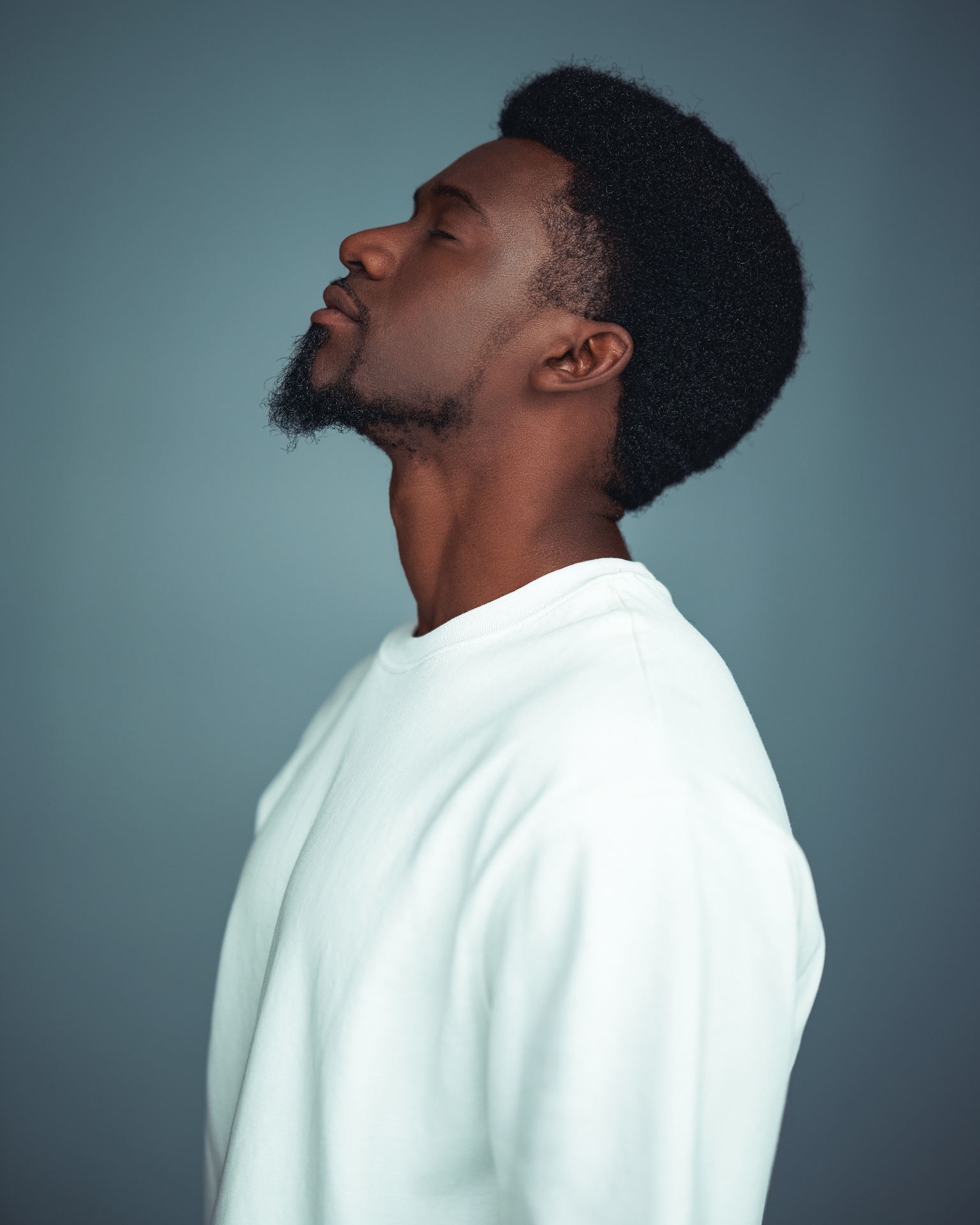 Kamanga profile portrait against a blue backdrop